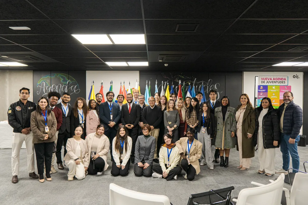 A delegation photographed in front of national flags
